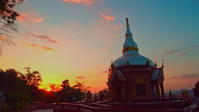 .Flares of light from the sun and colorful sunsets appear in the sky above the beautiful pagoda..On the top of the mountain at the temple behind Phuket Shrine.