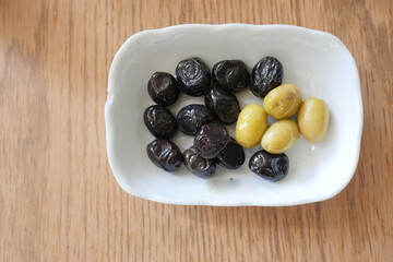 Collection of black and green olives with leaves.