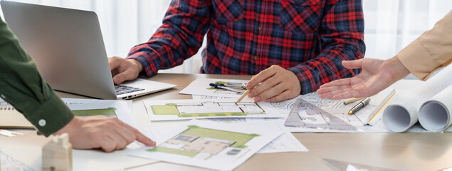 Professional architect design a blueprint by using laptop during project manager shows mistake...