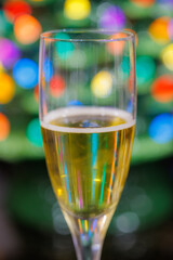 Festive Champagne Glass Toast with Colorful Christmas Bokeh Lights