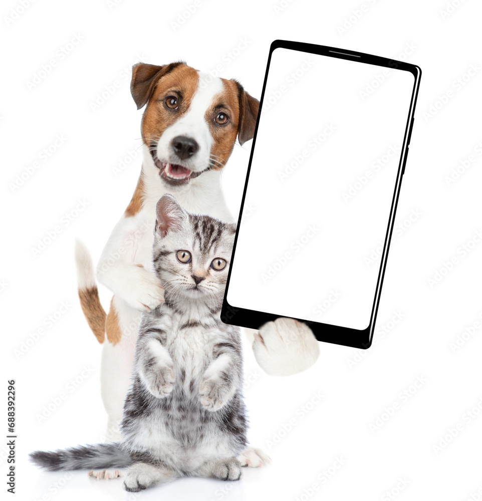 Poster jack russell terrier puppy hugs kitten and holds big smartphone with white blank screen in it paw, s