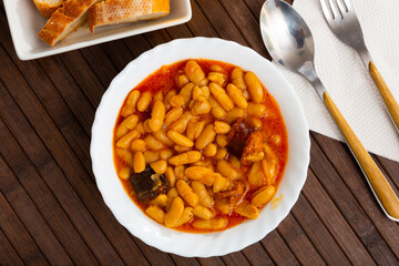 Traditional Asturian rich beans stew Fabada with pork shoulder, morcilla and chorizo served in...