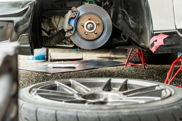 Close up car mechanic changing disc brake tire in auto repair