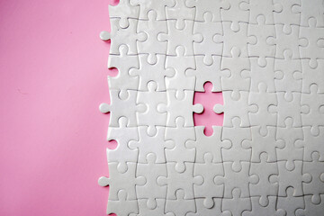 White jigsaw puzzle pattern missing pieces on pink background. Concept for expressing problem success solution alliance union teamwork - obrazy, fototapety, plakaty