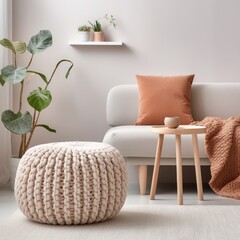 Scandinavian home interior design of modern living room. Knitted pouf, fabric sofa with blanket and...