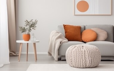 Scandinavian home interior design of modern living room. Knitted pouf, fabric sofa with blanket and...