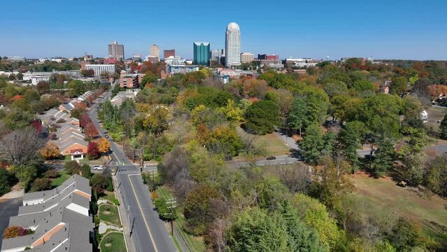 Winston-Salem, North Carolina during autumn. Aerial view of houses, trees, and city skyline in NC.