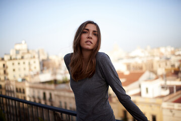 portrait of a young white and brunette woman looking at camera with Barcelona in the background