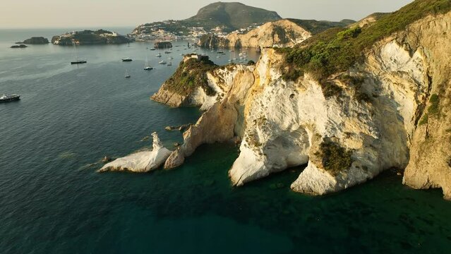 Wide drone panning shot of the tuff and kaolin rock formation at the secret Isola di Ponza on a sunny day