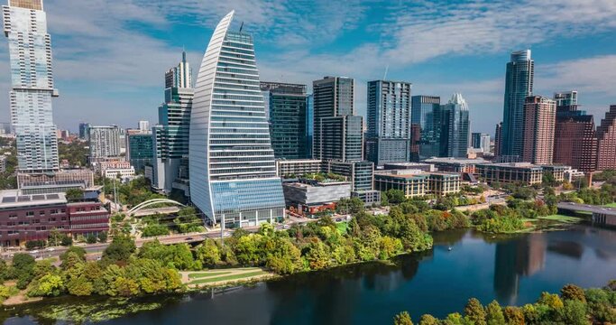 2024 Downtown Austin Texas skyline and Town Lake aerial hyperlapse on beautiful sunny fall day, drone pull away time lapse of traffic and buildings