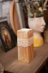 Candle in a wooden stand on the shelf