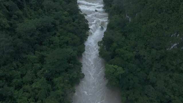 Reveal shot of brown Semuc champey waterfall at Guatemala, aerial