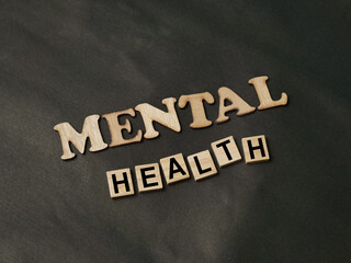 Mental health text written on wooden lettering, psychology well-being
