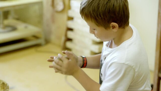 A boy works with clay in the ceramics studio