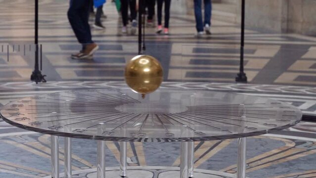 View of the famous Foucault Pendulum copper ball swinging inside the Pantheon in Paris. Known as one of the most impressive world’s cultural center.