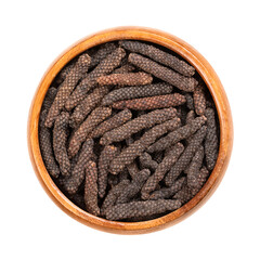 Dried long pepper catkins, in a wooden bowl. Fruits of Piper longum, sometimes called Indian long...