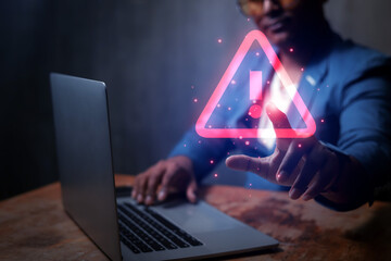 Businessman uses laptop computer with warning triangle sign or exclamation mark for error notification and technology maintenance concept.
 - obrazy, fototapety, plakaty