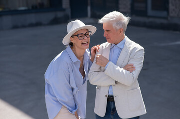Stylish elderly laughing couple on a walk. Romantic relationships of mature people. 