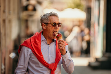 Senior man taking a slow walk, delighting in an ice cream cone