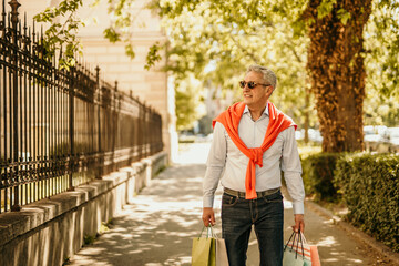 A laid-back image of a senior man effortlessly managing his shopping bags, reflecting his...