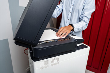 Unrecognizable businessman using printer in the modern office close up
