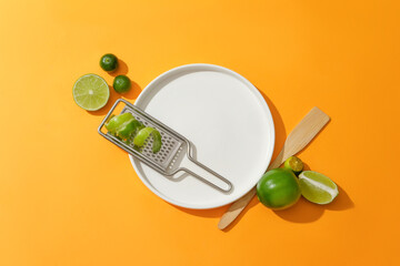 A grater with kumquat peel on a round ceramic plate. Bright background with orange color. Lemon and kumquat are two fruits that contain a lot of vitamin C to help brighten the skin.