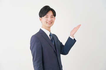 手のひらで右側を指すビジネスマン　白背景