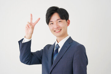 ピースサインをするビジネスマン　白背景