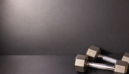 Used dumbbells, black background, black floor