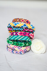 Pile de bracelets brésiliens avec une rose blanche