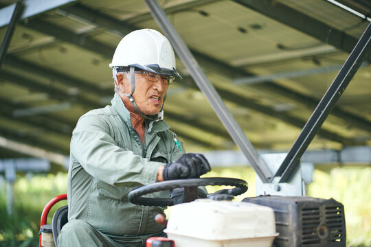 草刈りをする日本人シニア男性