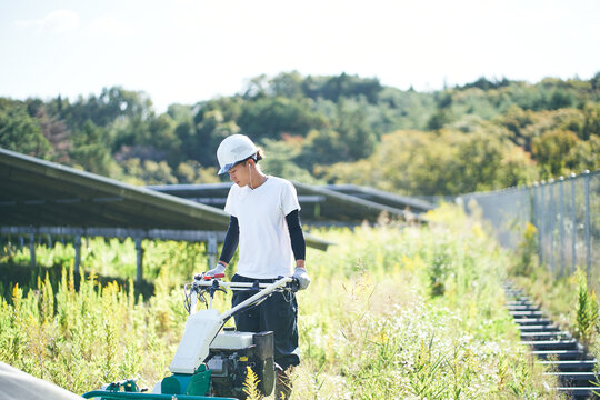 草刈りをする日本人男性