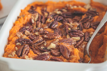 Traditional sweet potato casserole with pecan, white background.