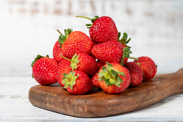 Fresh strawberries on a white wooden background. Organic agricultural products. Delicious ripe strawberries