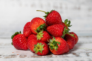Fresh strawberries on a white wooden background. Organic agricultural products. Delicious ripe strawberries