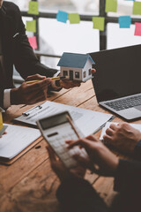 Entrepreneurs, business owners, accountants and real estate agents meet, discuss and use calculators to calculate budgets for purchasing a home project and calculate financial risks for clients.