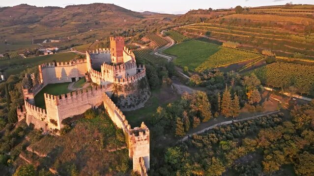 Restored Soave Castle Surrounded By Vineyards During Sunset In Soave, Verona, Northern Italy. Aerial Drone Shot