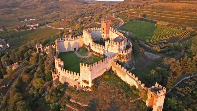 Scaligero Castle Of Soave In Northern Italy. Ancient Walls Over Medieval Village During Sunset. Aerial Drone Shot