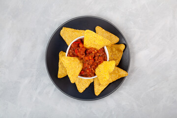 Chili con carne, top view. Traditional Mexican spicy dish with red beans, peppers, tomatoes and minced meat. Delicious spicy Chili con carne with tortilla chips