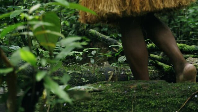 Footsteps of indigenous guy walking along a path in the dense forest in Leticia, Amazon, Colombia