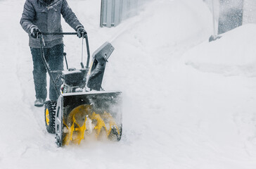Snowplow. Man removes snow with a snowblower in winter day