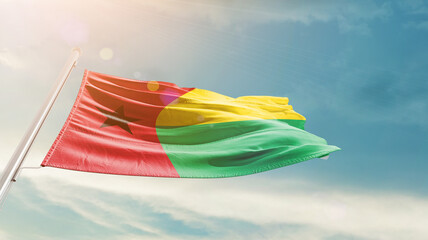 Guinea-Bissau national flag waving in beautiful sky. The symbol of the state on wavy silk fabric.