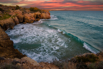 Mediterranean coast at sunset with waves