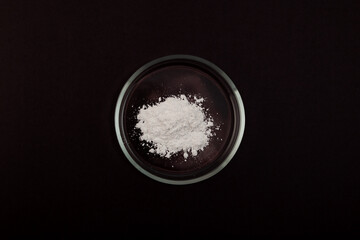 Titanium dioxide powder in Petri dish, top view. TiO2 also known as titanium (IV) oxide or Titania....