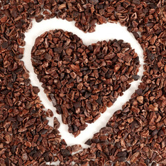 Pile of Cacao nibs, close-up. Crunchy pieces of peeled, crushed and lightly roasted cocoa beans with pleasant chocolate bitterness. Sugar-free product,  Natural antidepressant