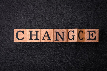 The inscription chance or change with wooden cubes on a dark concrete background