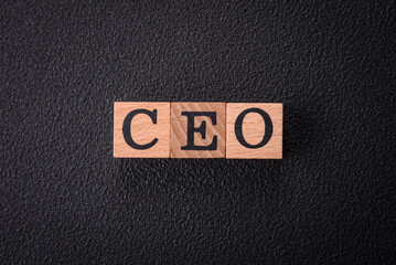 The inscription ceo in wooden cubes on a dark concrete background