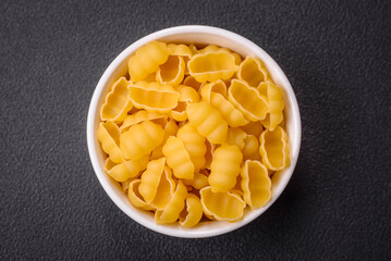 Raw durum wheat gnocchi pasta with salt and spices in a ceramic plate