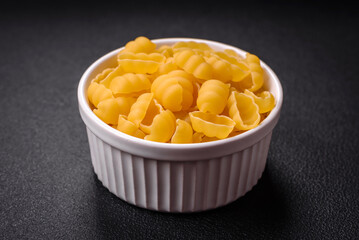 Raw durum wheat gnocchi pasta with salt and spices in a ceramic plate