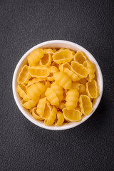 Raw durum wheat gnocchi pasta with salt and spices in a ceramic plate